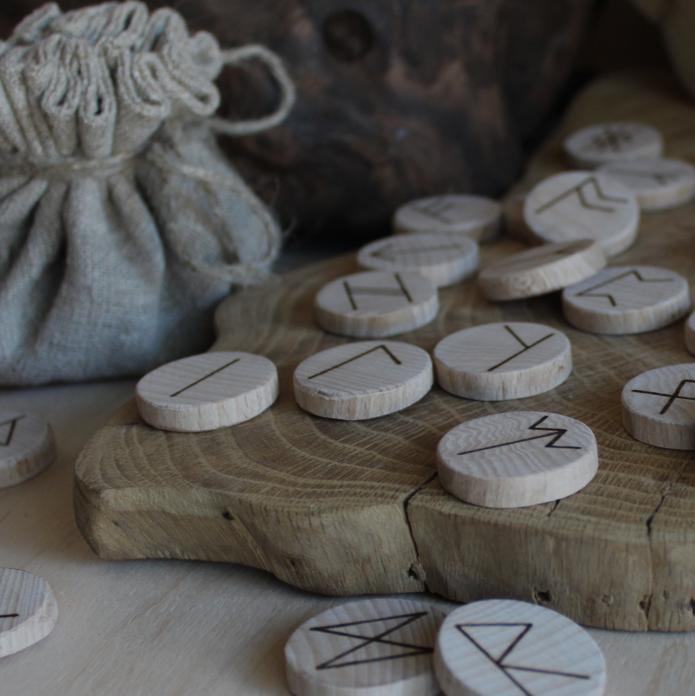 Worek, wokół którego leżą drewniane klocki z napisanymi znakami wikingów