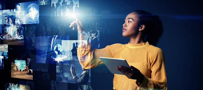 młoda kobieta z tabletem wskazująca na obrazy na ekranie holograficznym