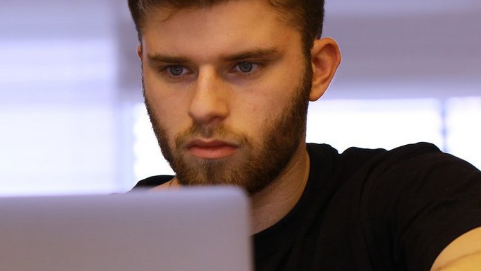 A young man looking at the computer screen