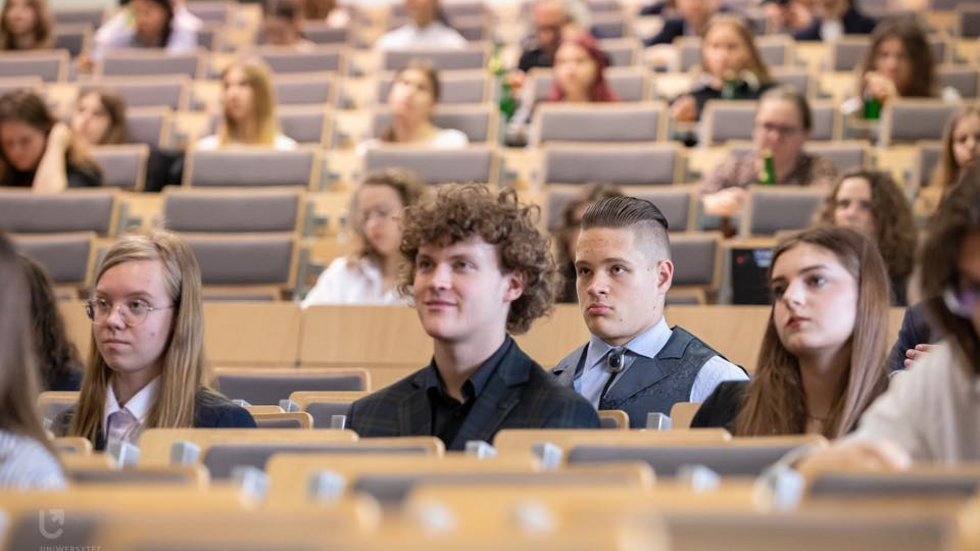 Studenci siedzą w auli Uniwersytetu Łódzkiego.