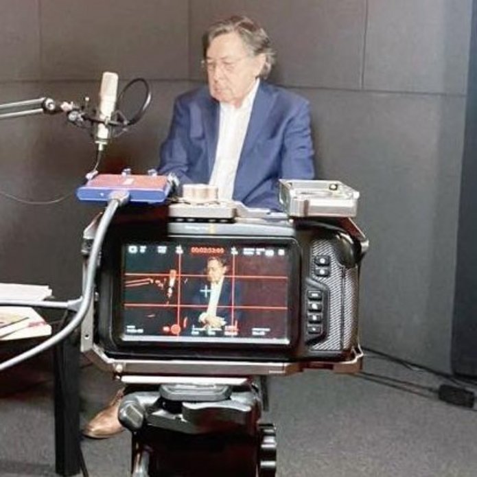 Kamera nagrywająca mężczyznę w marynarce.