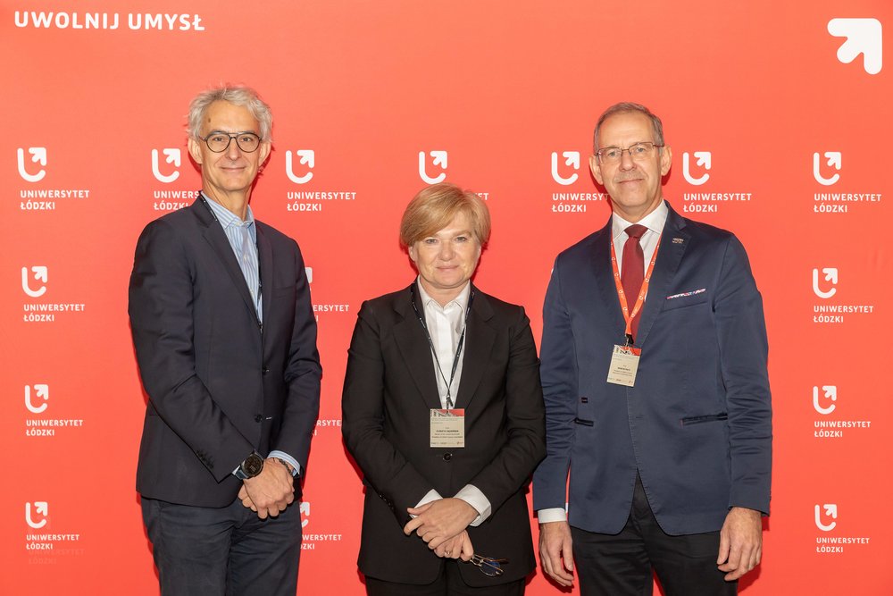 three scientists on the background of the wall with the logos of the University of Lodz