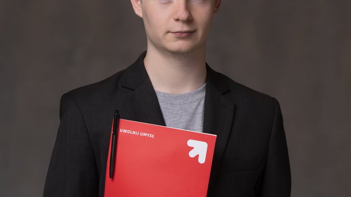 Młody mężcyzna trzymający teczkę papierową z napisem Uwolnij umysł
