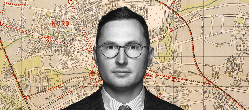 Dr Adam Sitarek na tle fragmentu mapy łódzkiego getta Dr Adam Sitarek na tle fragmentu mapy łódzkiego getta