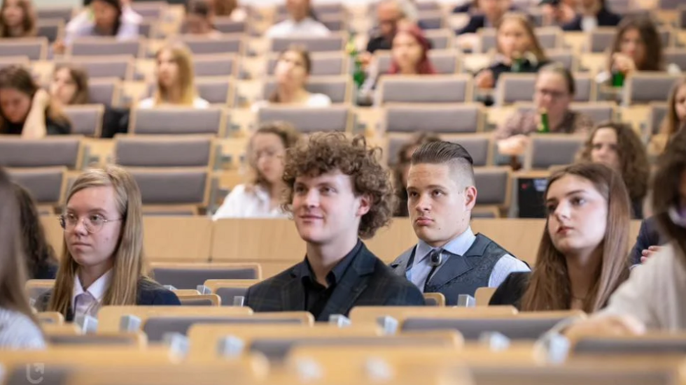 Students sitting in front of the auditorium of the University of Lodz.