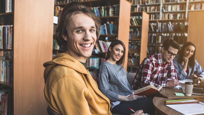 młodzi ludzie siedzą przy biurku