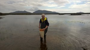 Zdjęcie profesora Mirosława Przybylskiego stojącego w woderach w wodzie Zdjęcie profesora Mirosława Przybylskiego stojącego w woderach w wodzie