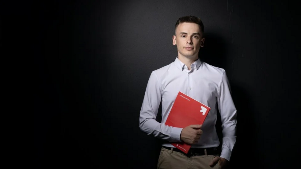 A University of Lodz student holding a red folder.