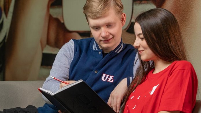 dwoje studentów dziewczyna i chłopak siedzą na sofie i coś czytają