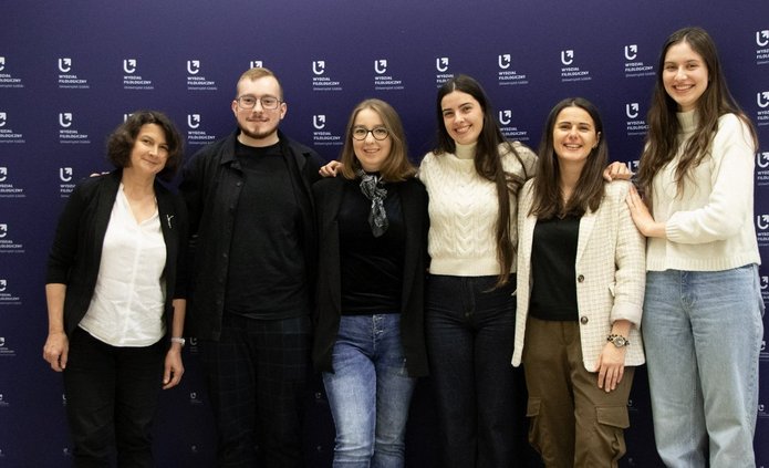 a photo of the entire project group in front of the faculty banner