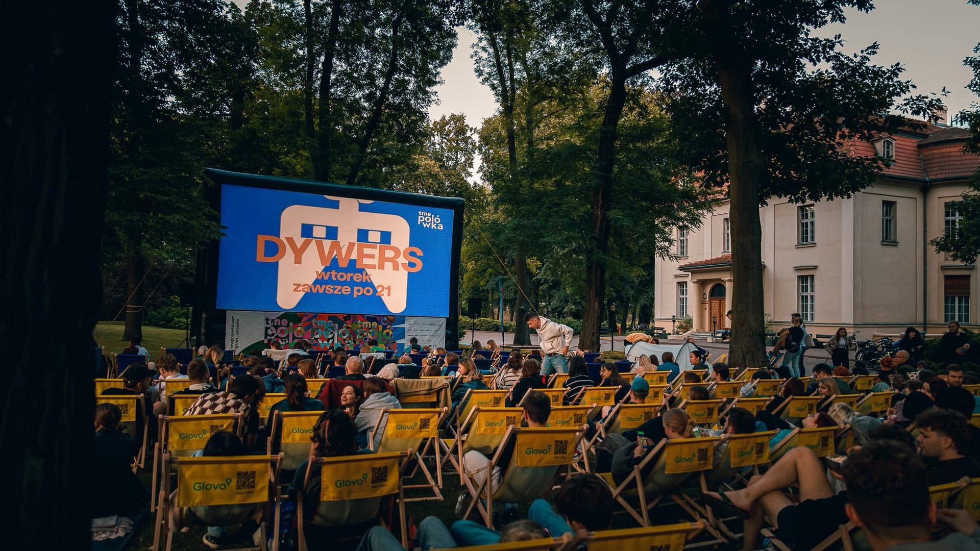 Grupa ludzi na leżakach w ogrodzie na sensie filmowym 
