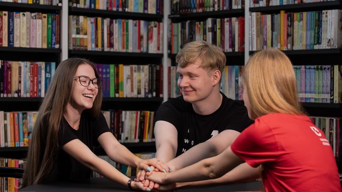 trójka studentów siedzi przy stole