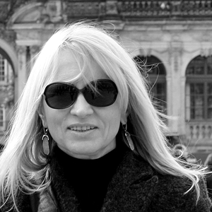 A portrait photo of Tamara Sass, a blond woman wearing sunglasses