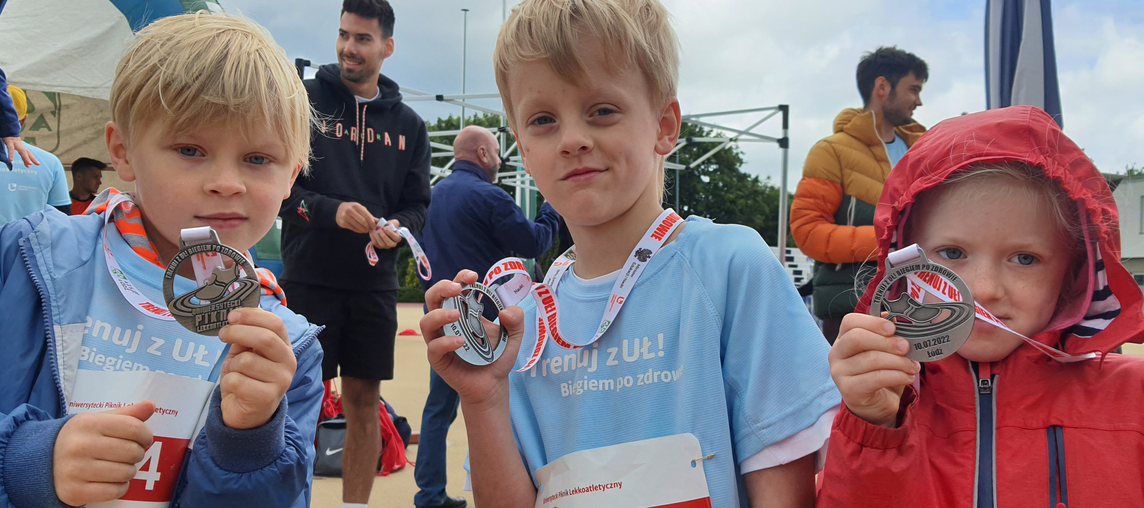 Trójka dzieci z medalami w czasie pikniku lekkoatletycznego