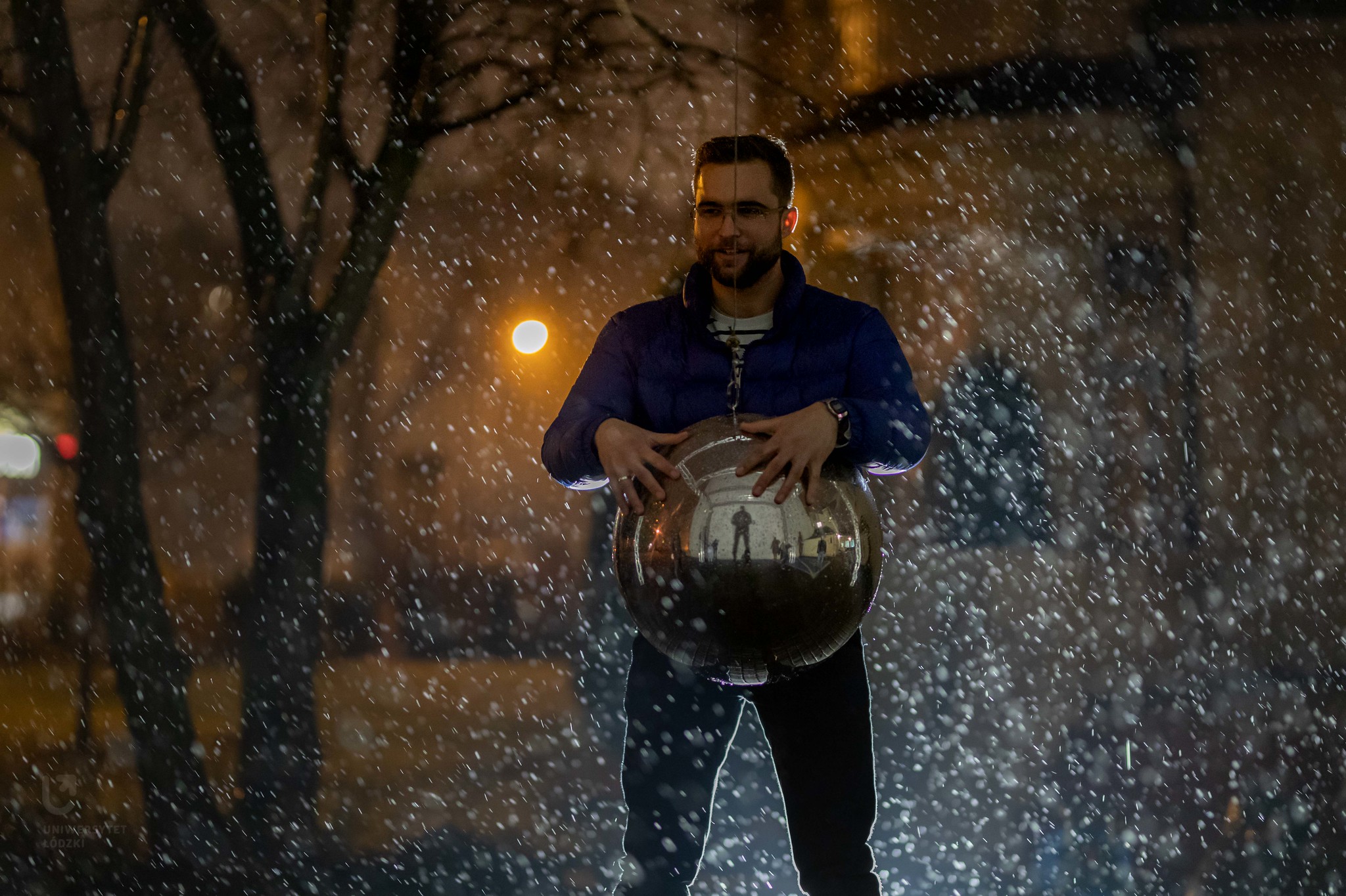 Uśmiechnięty chłopak w padającym śniegu