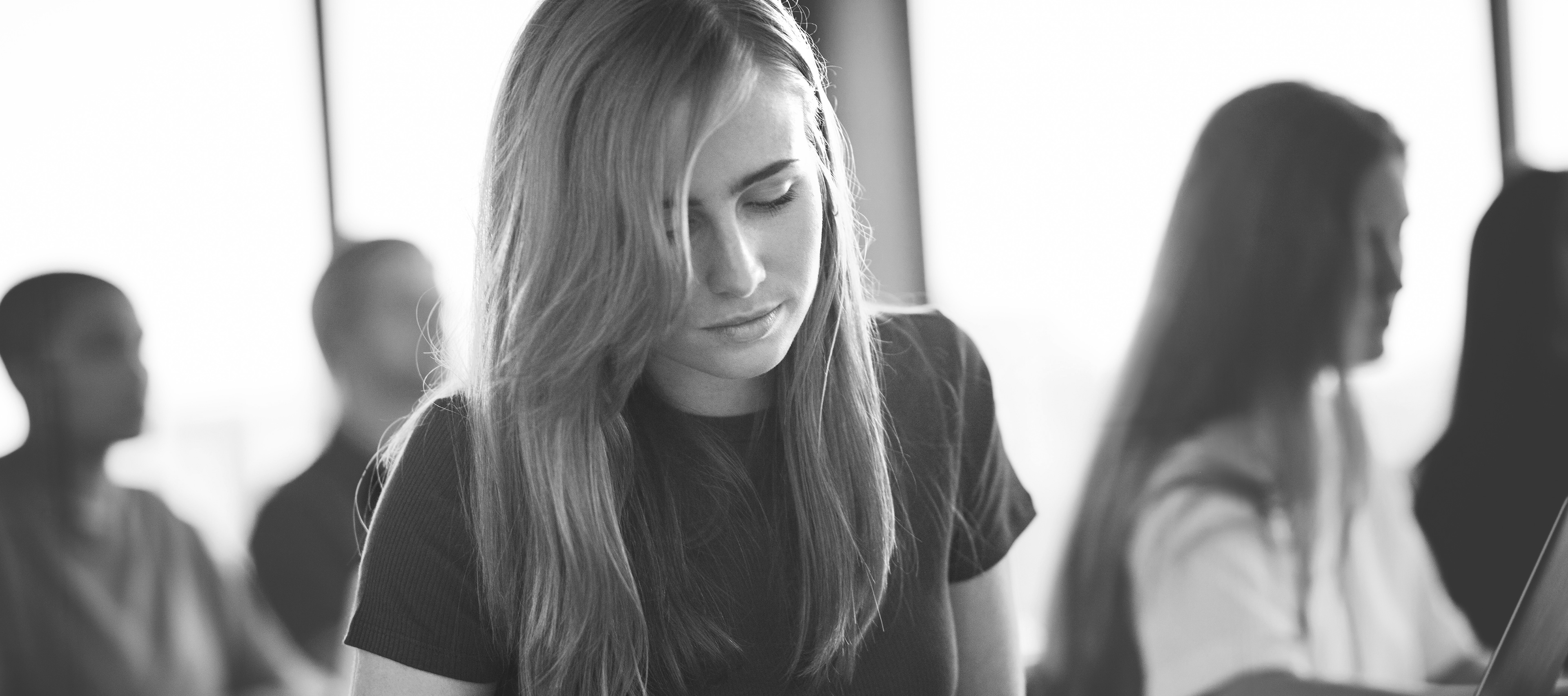 Młodzi ludzie siedzący w sali zajęciowej