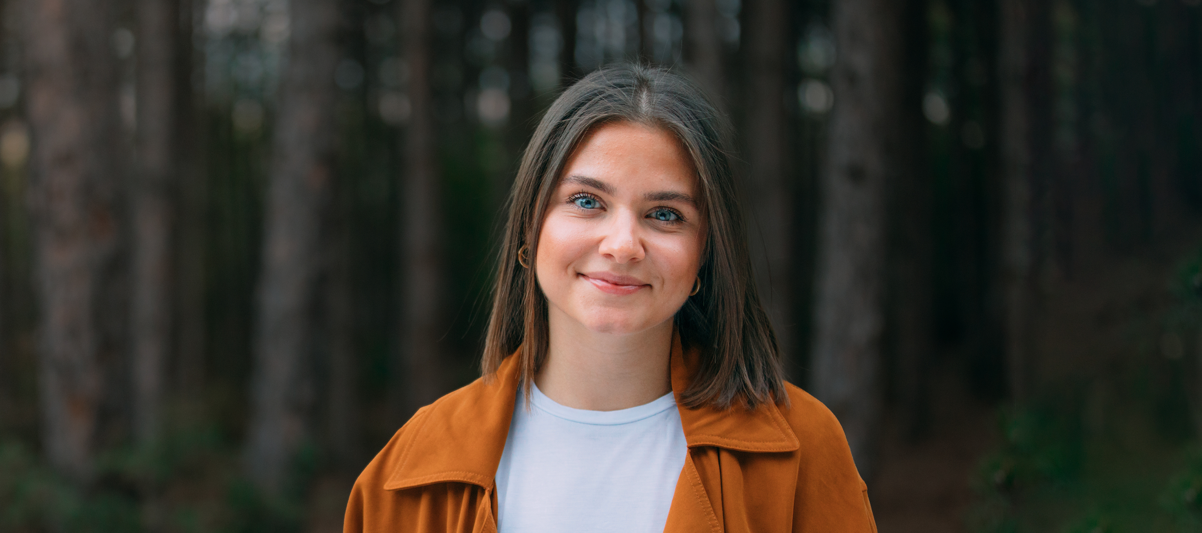 Młoda kobieta stojąca na tle drzew