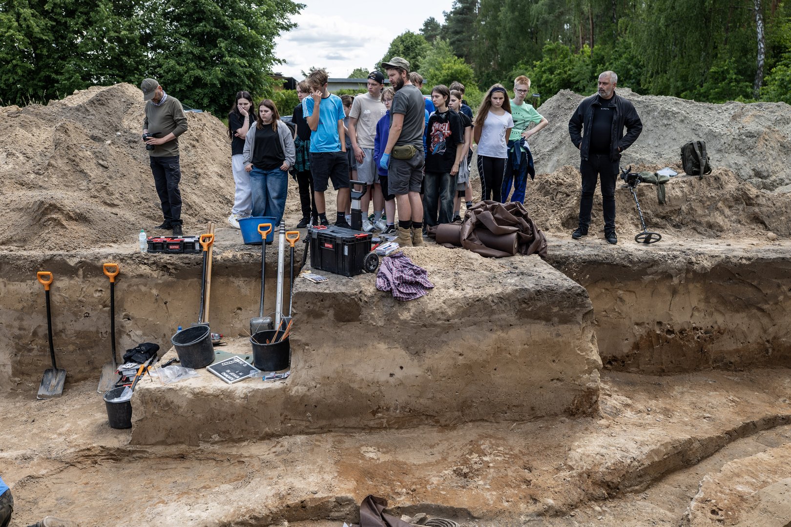 Dr Dawid Kobiałka prezentujący jeden z wykopów przybyłej na miejsce młodzieży Dr Dawid Kobiałka prezentujący jeden z wykopów przybyłej na miejsce młodzieży