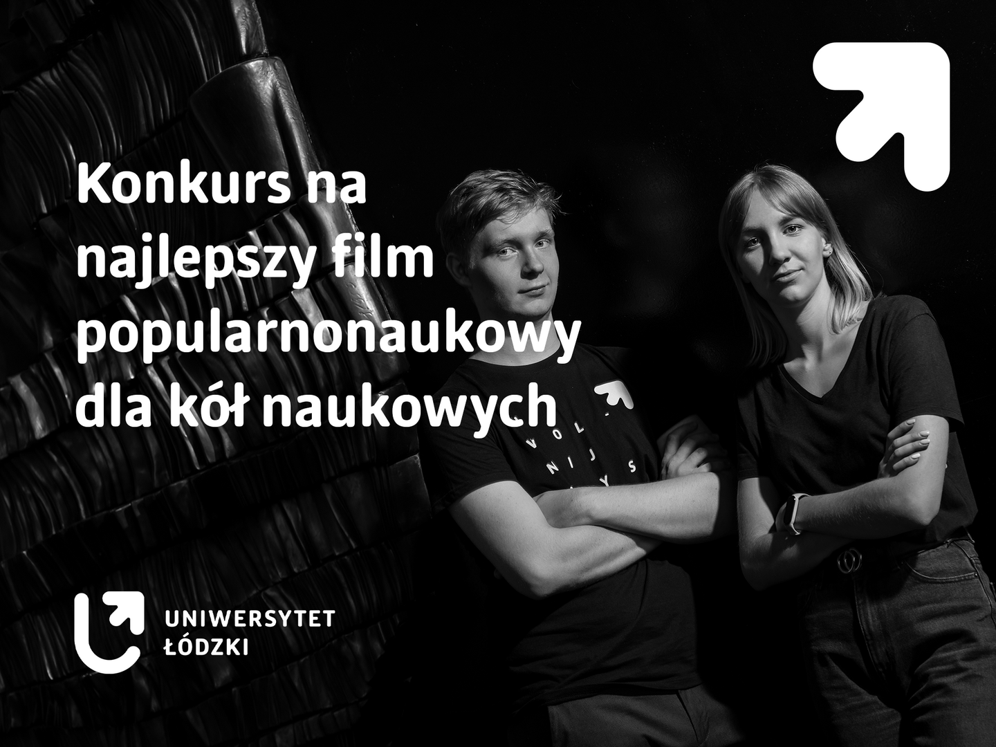 Baner z nazwą konkursu. Para studentów stojąca na wprost obiektywu.