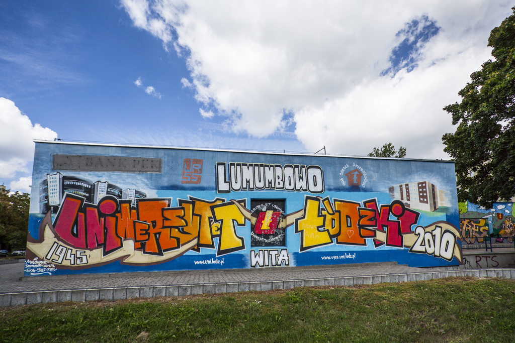 Kolorowe zdjęcie przedstawiające mural na budynku Centrum Obsługi Spraw Społecznych i Socjalnych Studentów i Doktorantów przy ulicy Patrice Lumumby 1; mural przedstawiaj napis: Lumumbowo, Uniwersytet Łódzki
