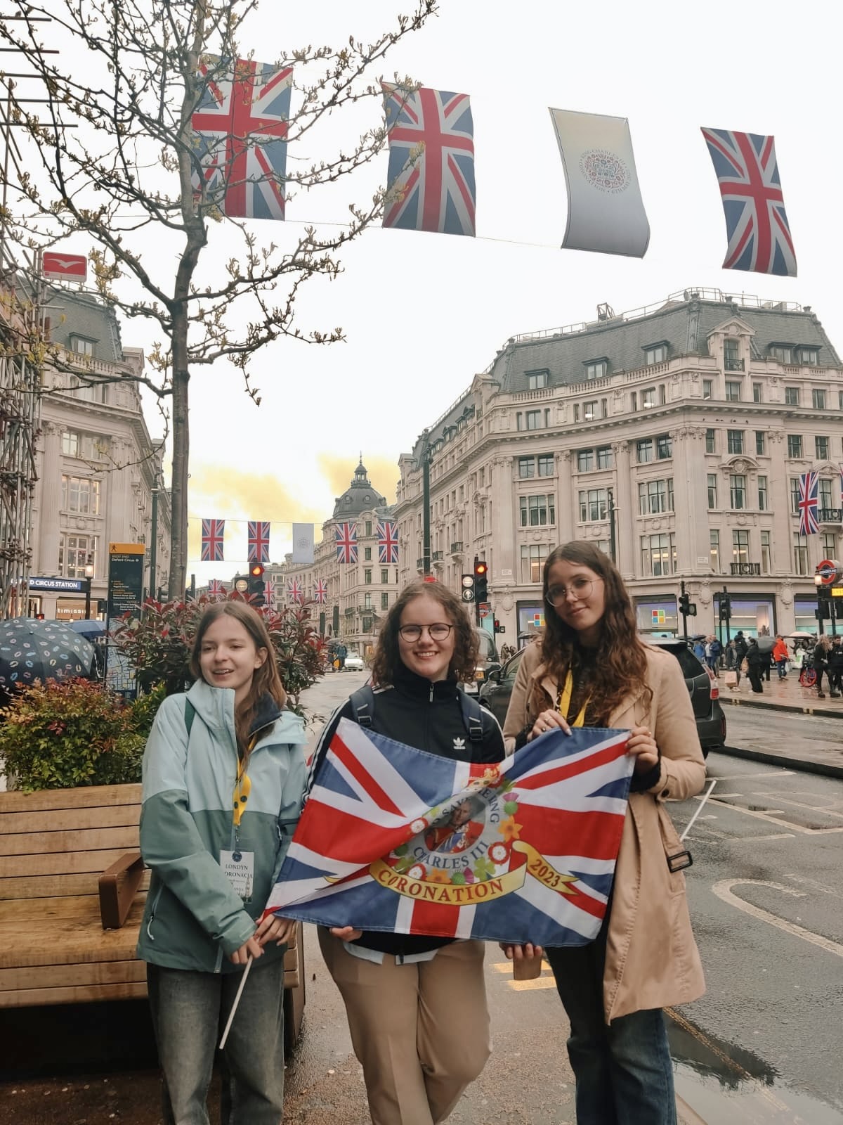 Three BISUL students holding a British flag standing in the streets of London 