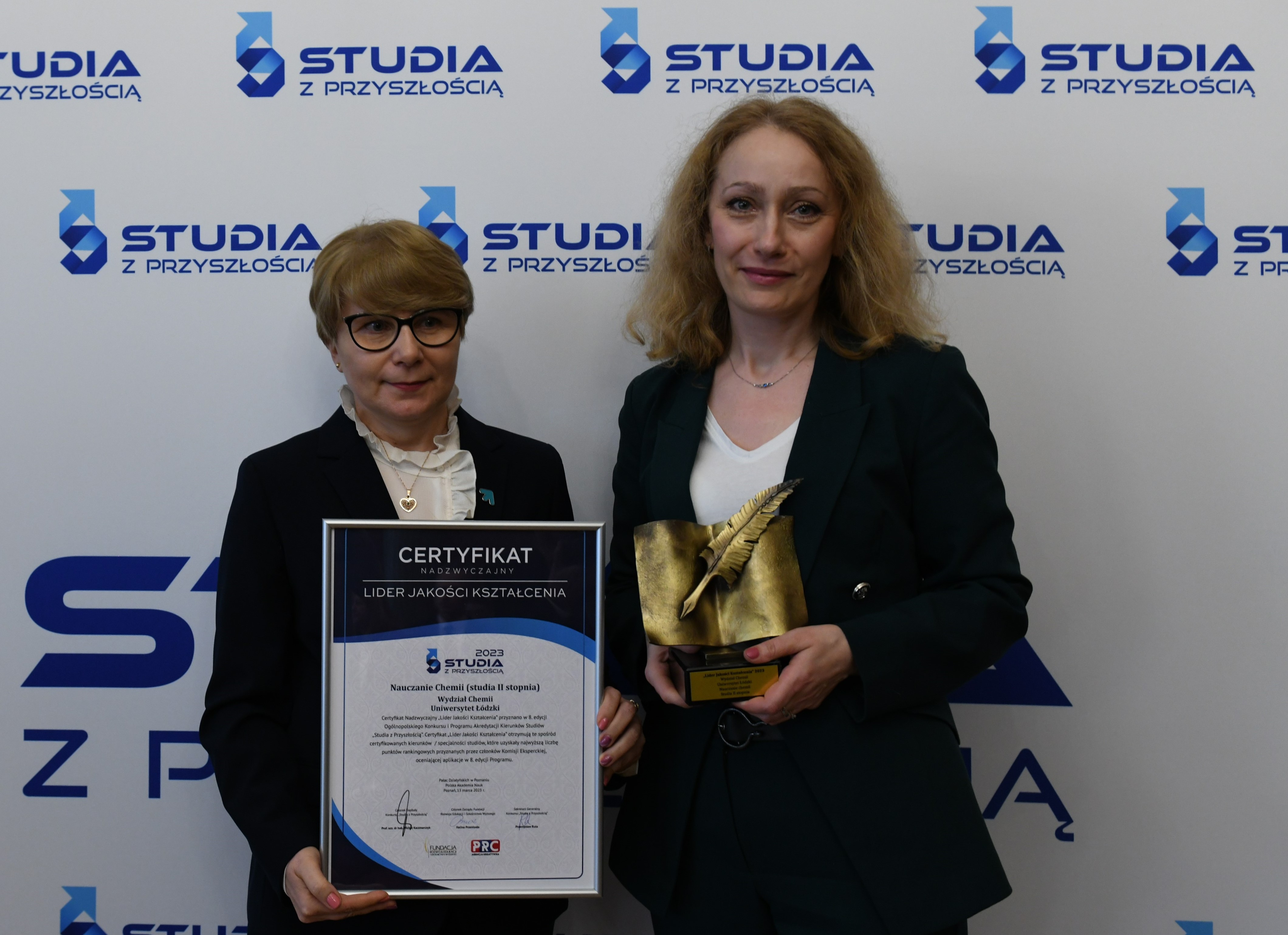 dwie kobiety z certyfikatem i statuetką