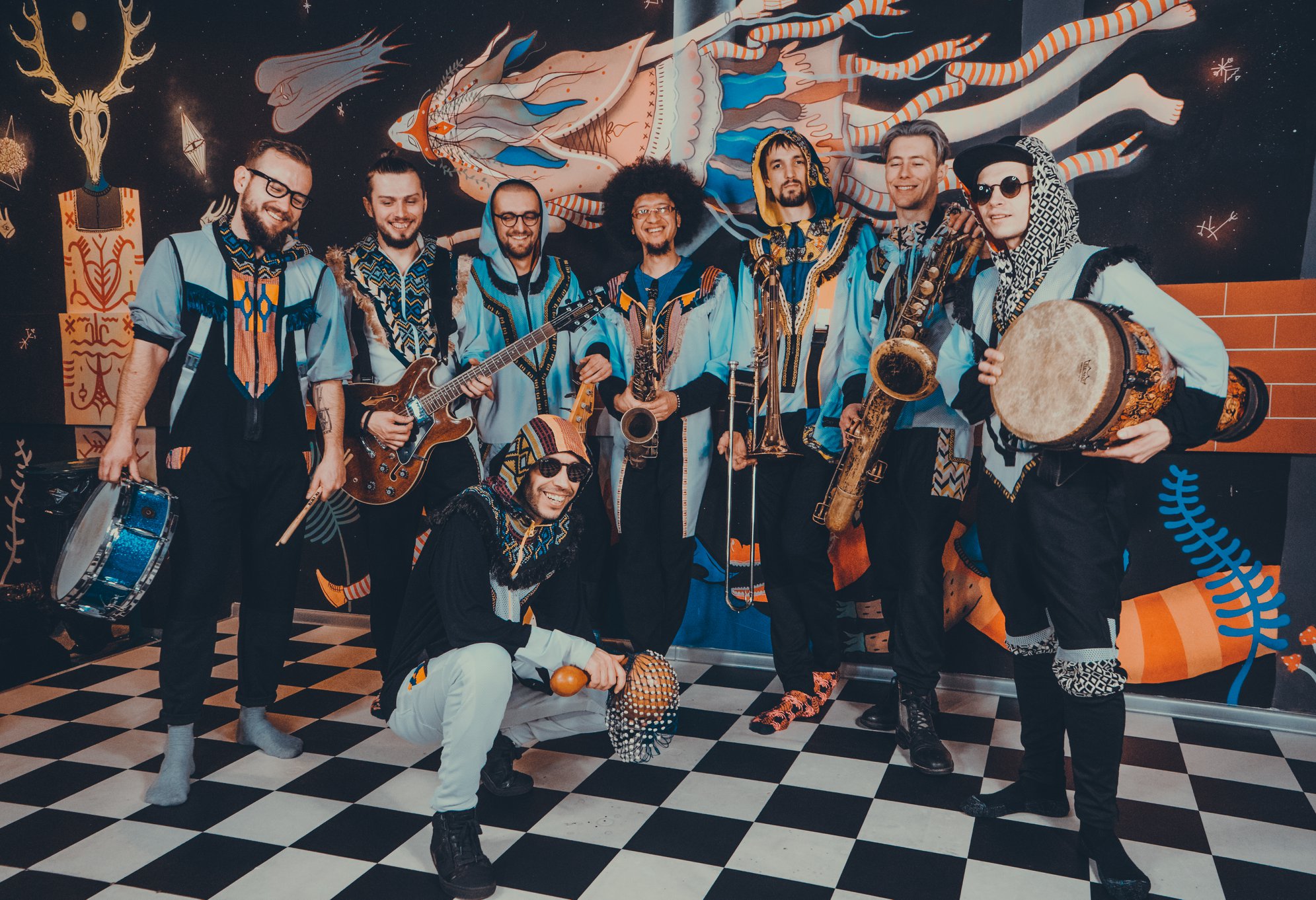 zespół muzyków w kolorowych strojach z afrykańskimi instrumentami