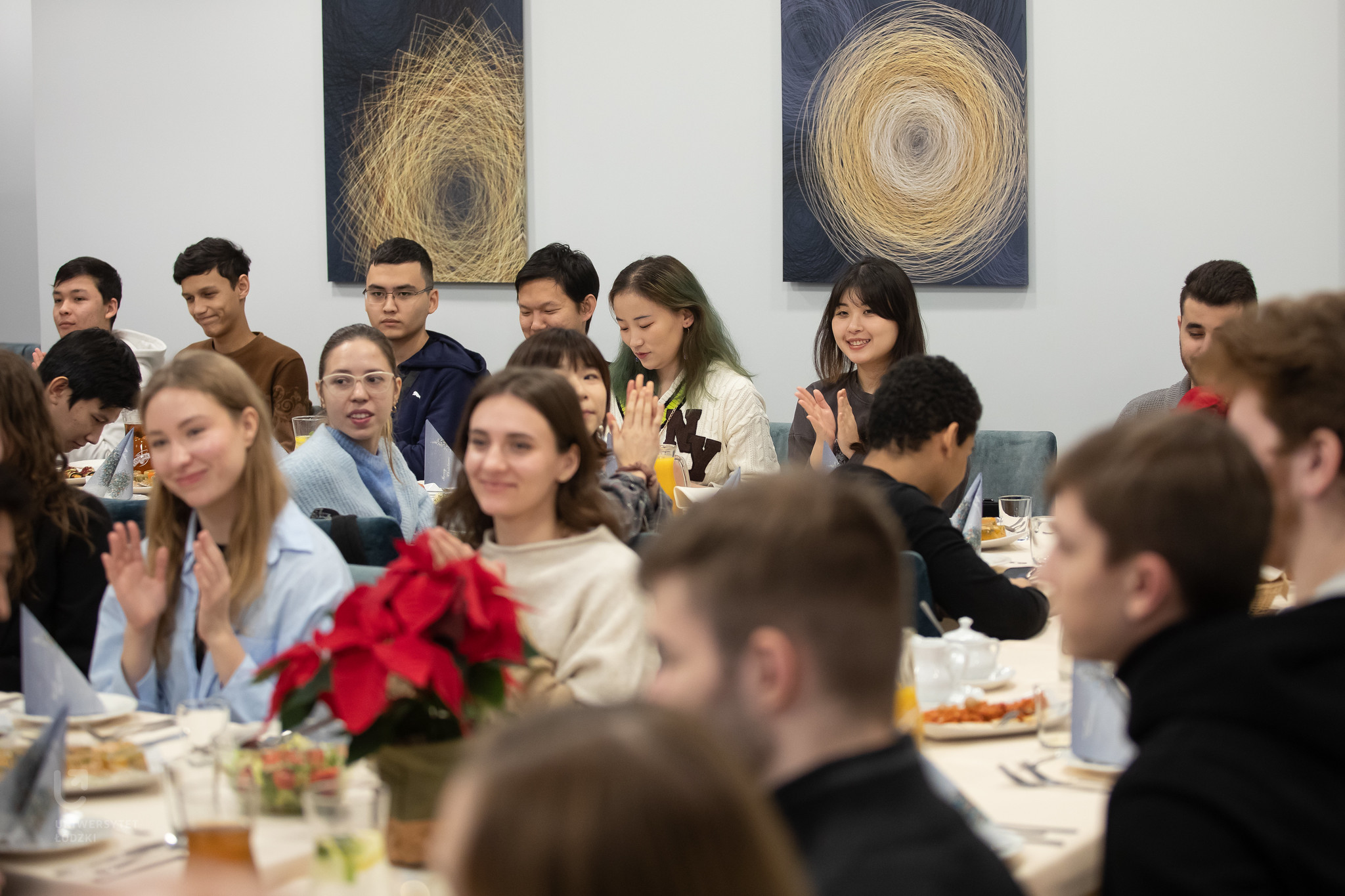 Kilkanaście osób siedzi przy stołach