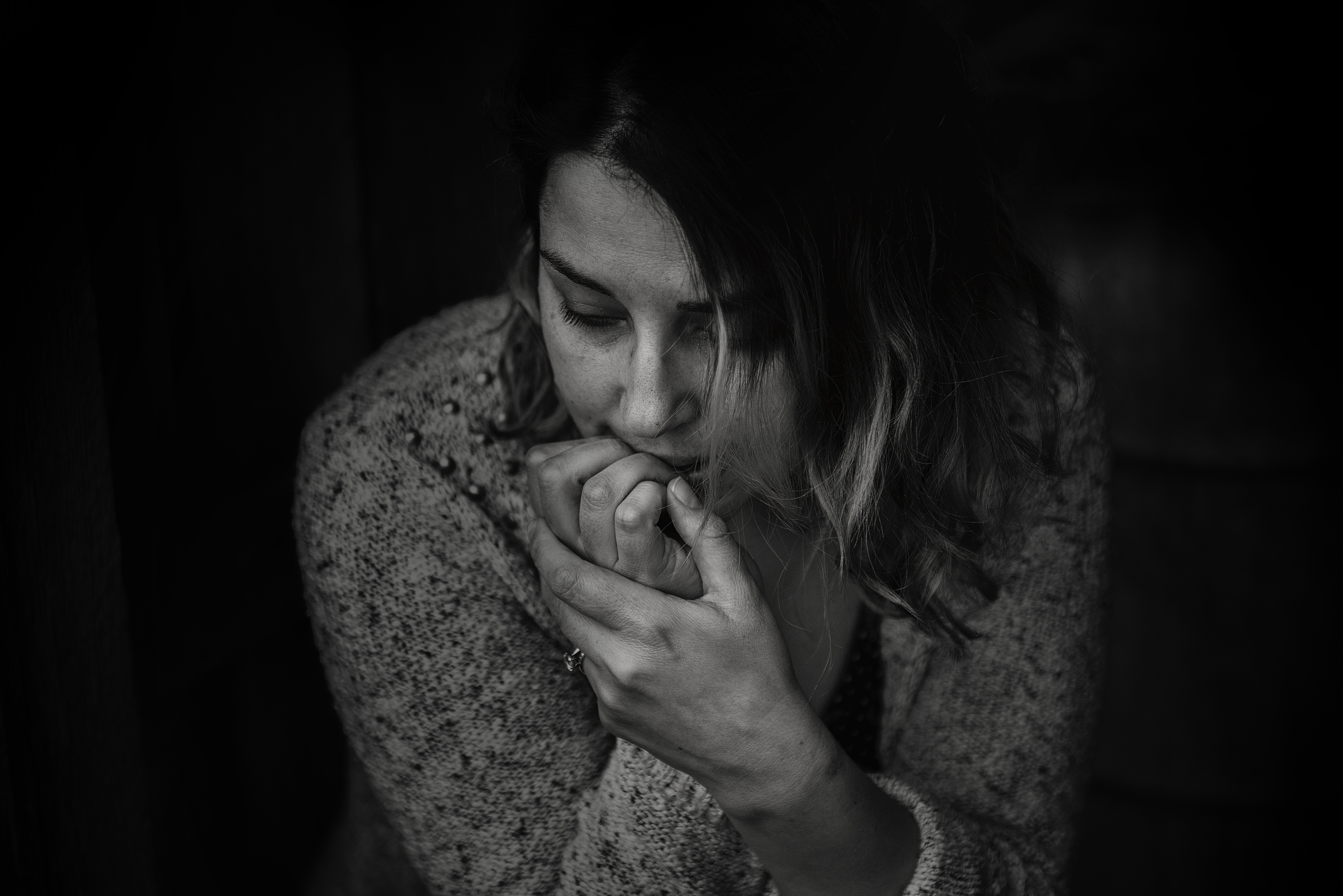 A black and white photo of a pensive woman