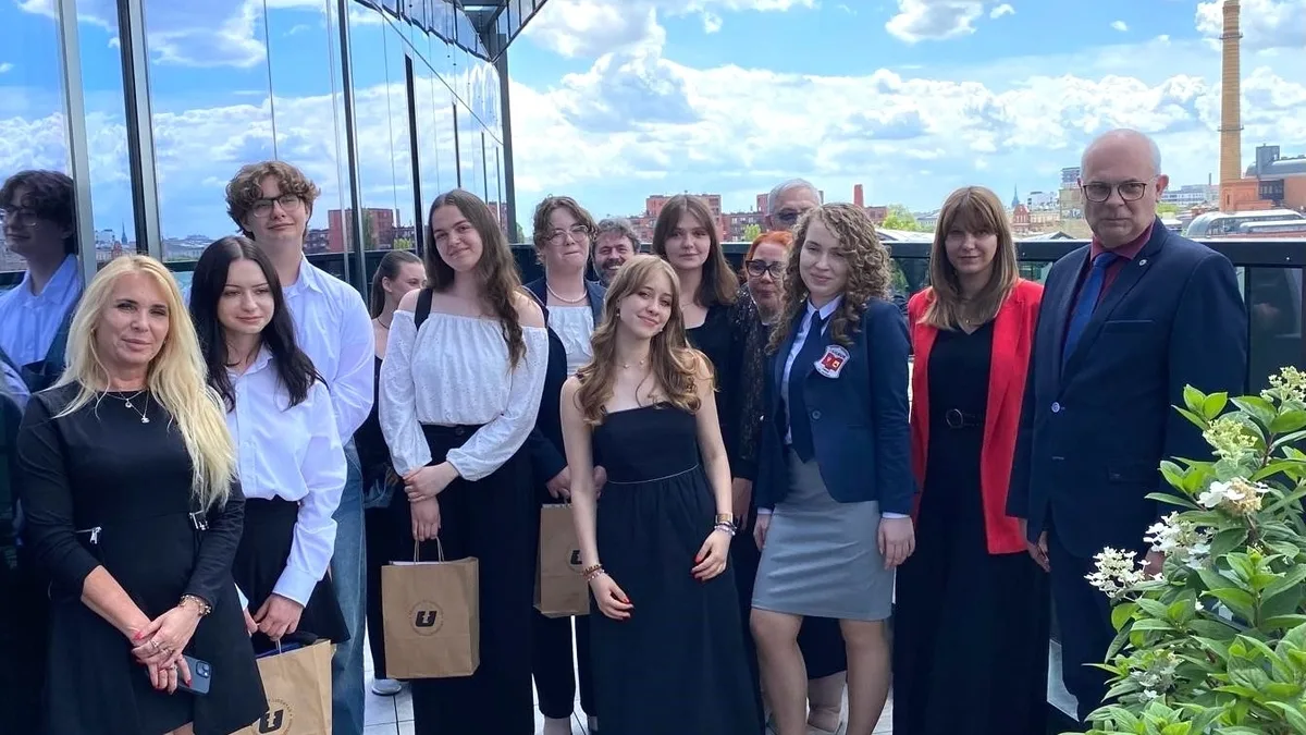 Grupa młodych ludzi stoi na tarasie wydziału UŁ