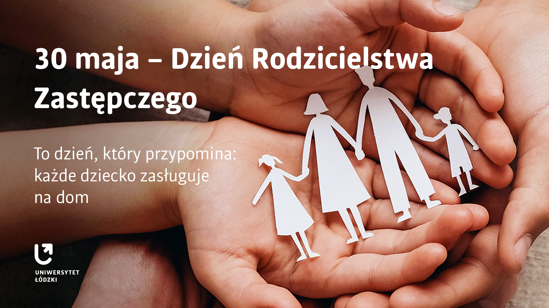 Dłonie na których położona jest wycinanka przedstawiająca rodzinę z dziećmi.