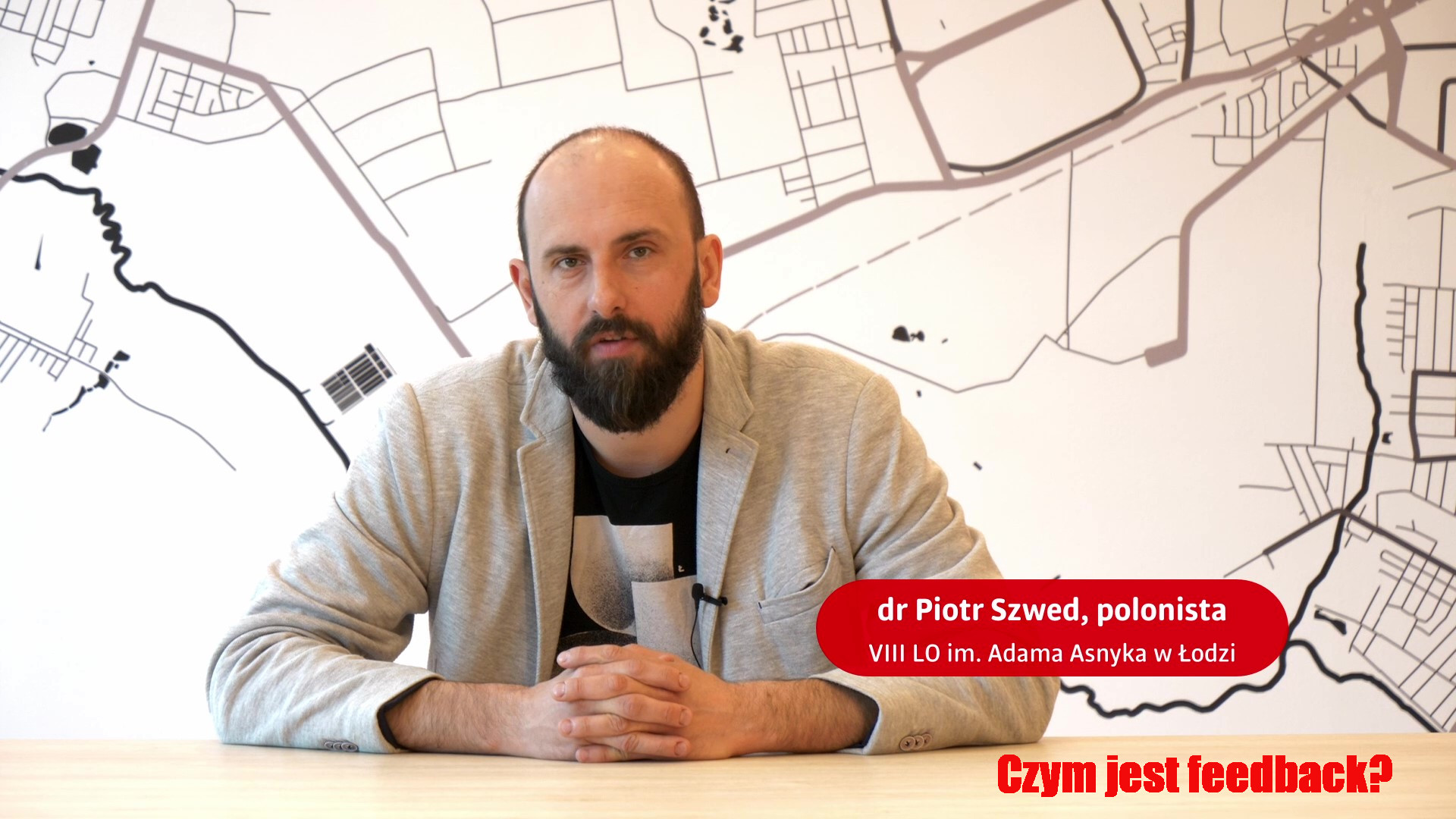 Mężczyzna siedzący przy stole - dr Piotr Szwed