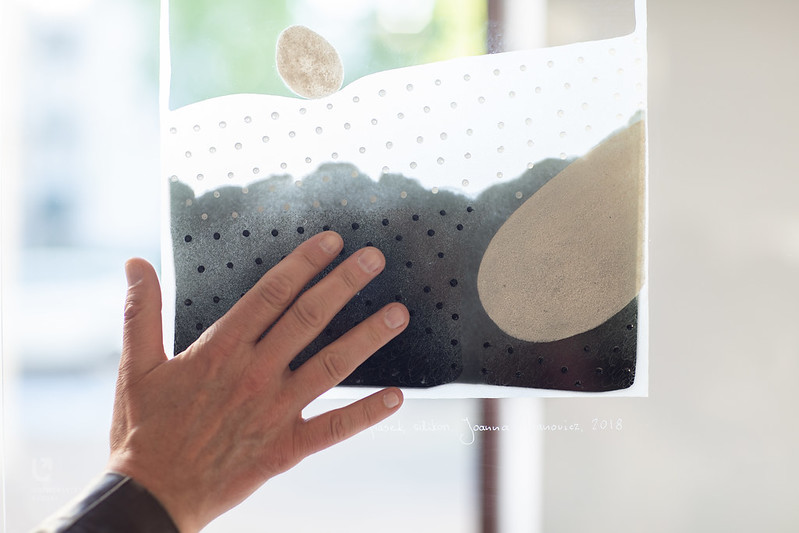 hand touching art work on glass