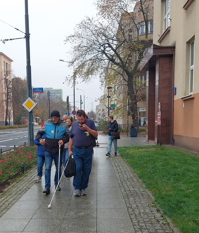 the same group of people walking along Narutowicza Street