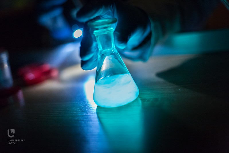 Zlewka z fluorescencyjną, świecącą na niebiesko cieczą