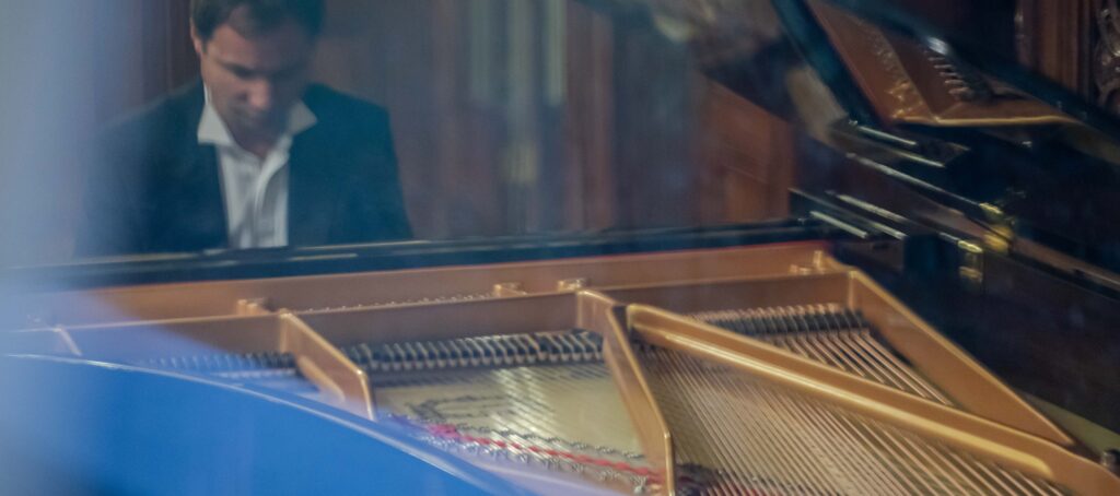 A man wearing a suit at the grand piano