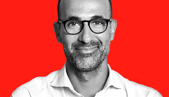 Mężczyzna w okularach na czerwonym tle 